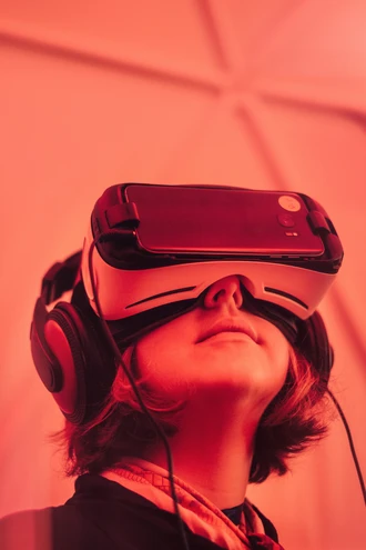 Girl looking up with VR glasses, all covered in a red hue.