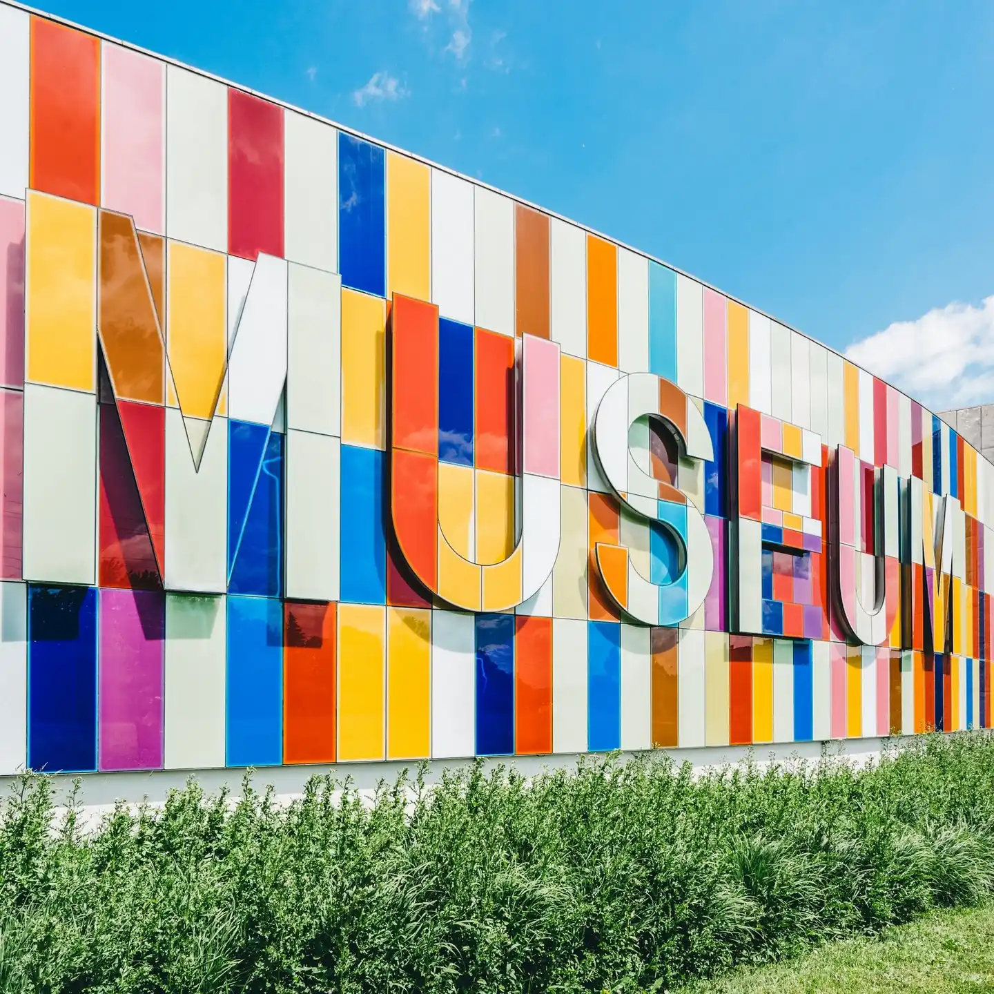 Outside wall of the museum covered in large colorful tiles with the word MUSEUM spelled out. 